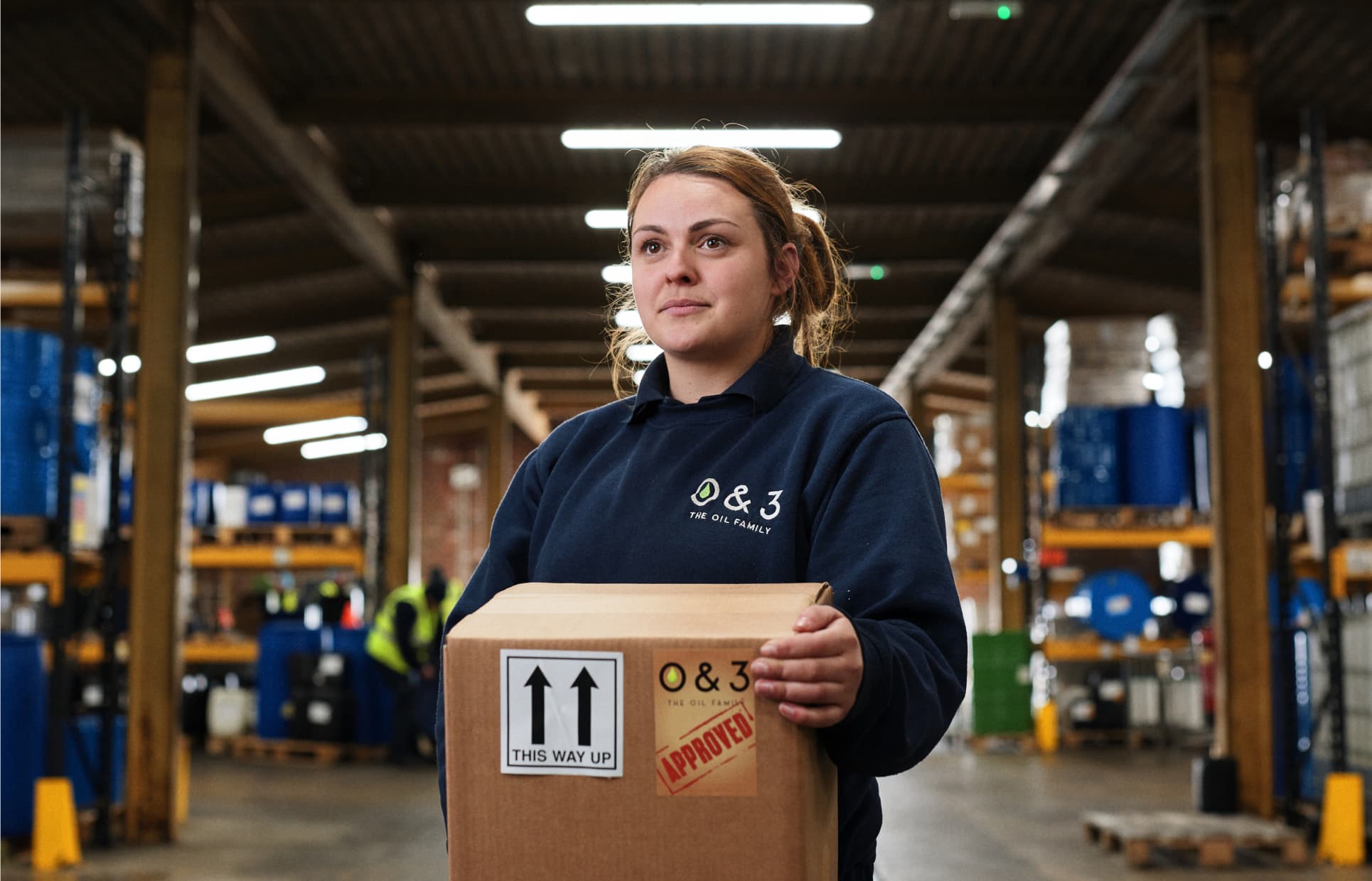 Woman in factor holding a box