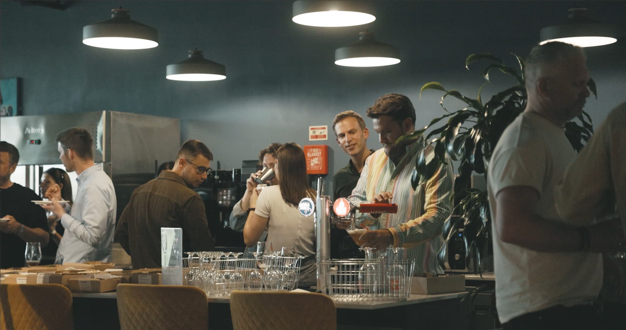 People pouring drinks and mingling at an office party 