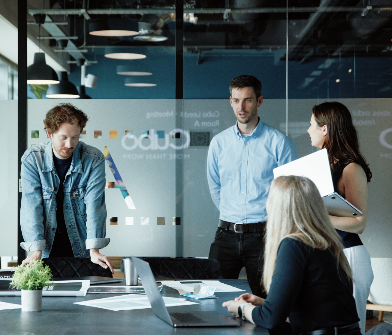 Designers and strategists actively engaged in a creative meeting, exchanging ideas and reviewing visual concepts together.